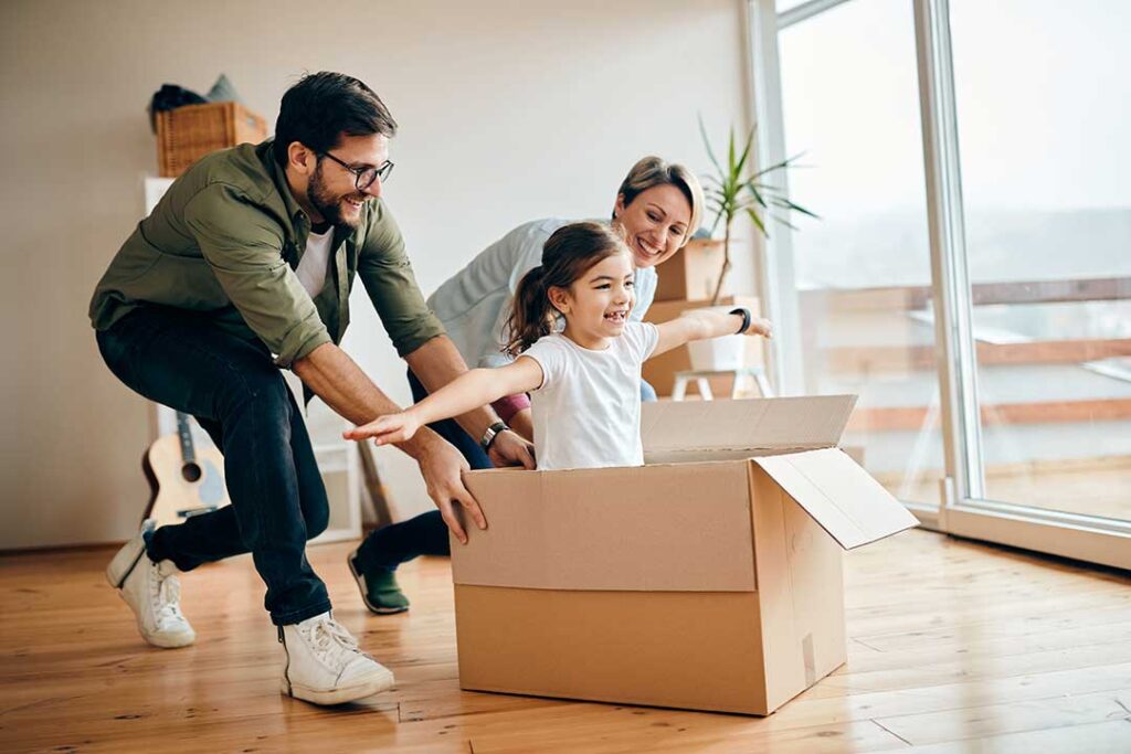 Two people reviewing a stack of home documents and checklist inside a bright, tidy living room.
