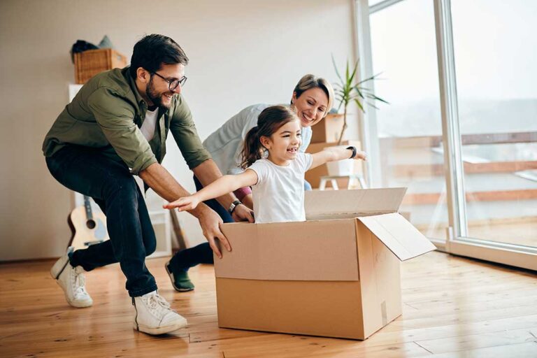 Two people reviewing a stack of home documents and checklist inside a bright, tidy living room.