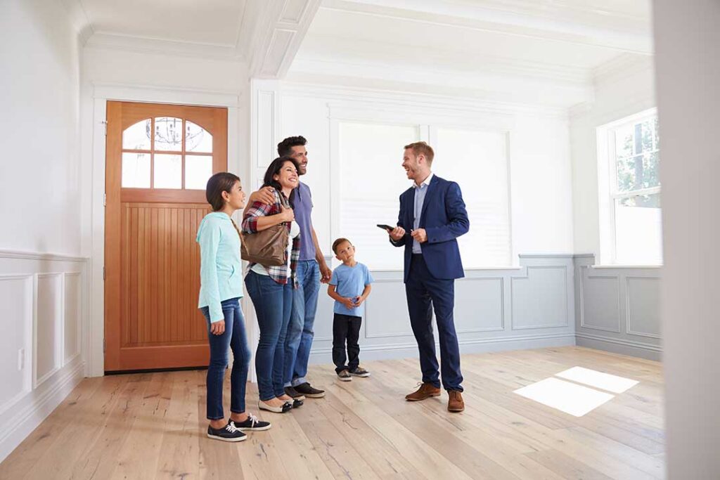 Two people reviewing documents together at a kitchen table with a notebook and coffee.